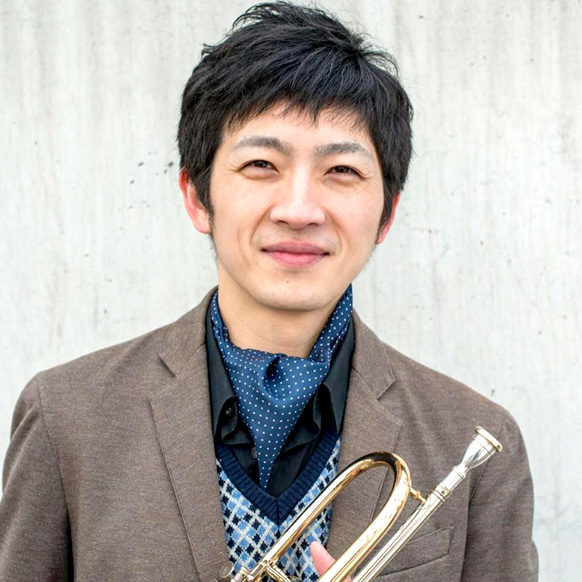 Mann lächelt mit einer Trompete in der hand