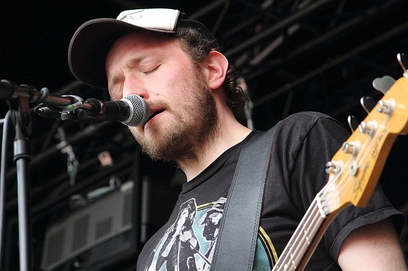 Mann mit kaputze Singt in das mikro