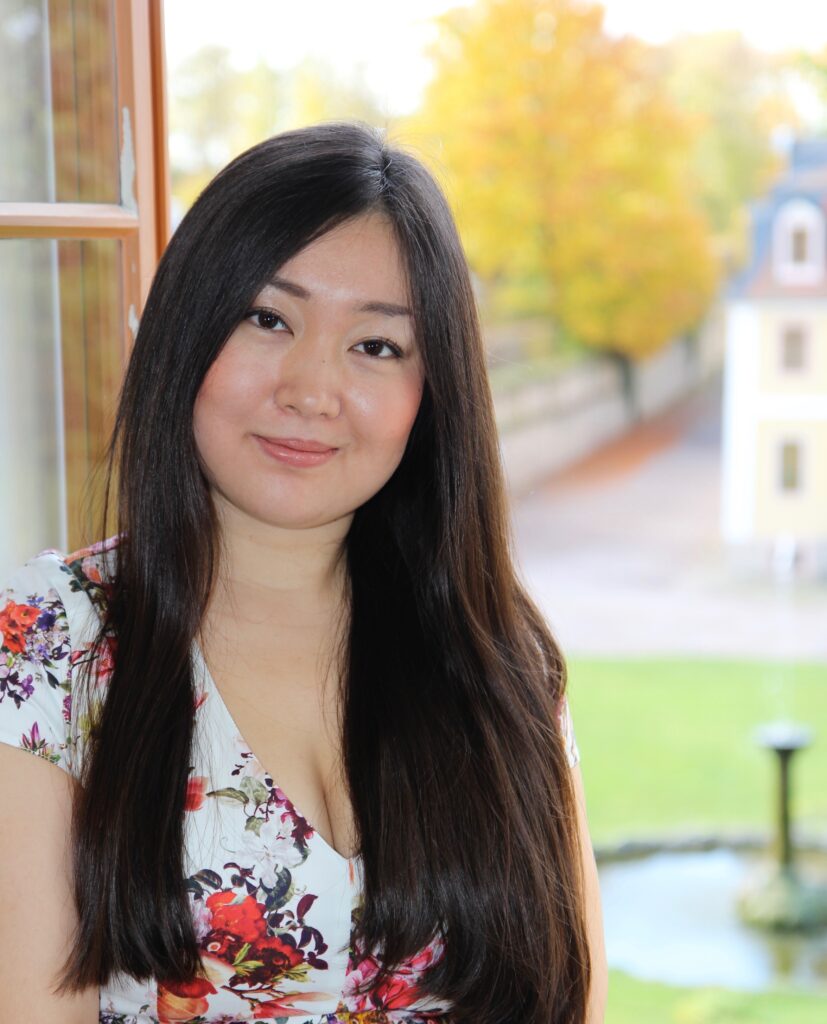 Frau die in die kamera lächelt im hintergrund sieht man bäume